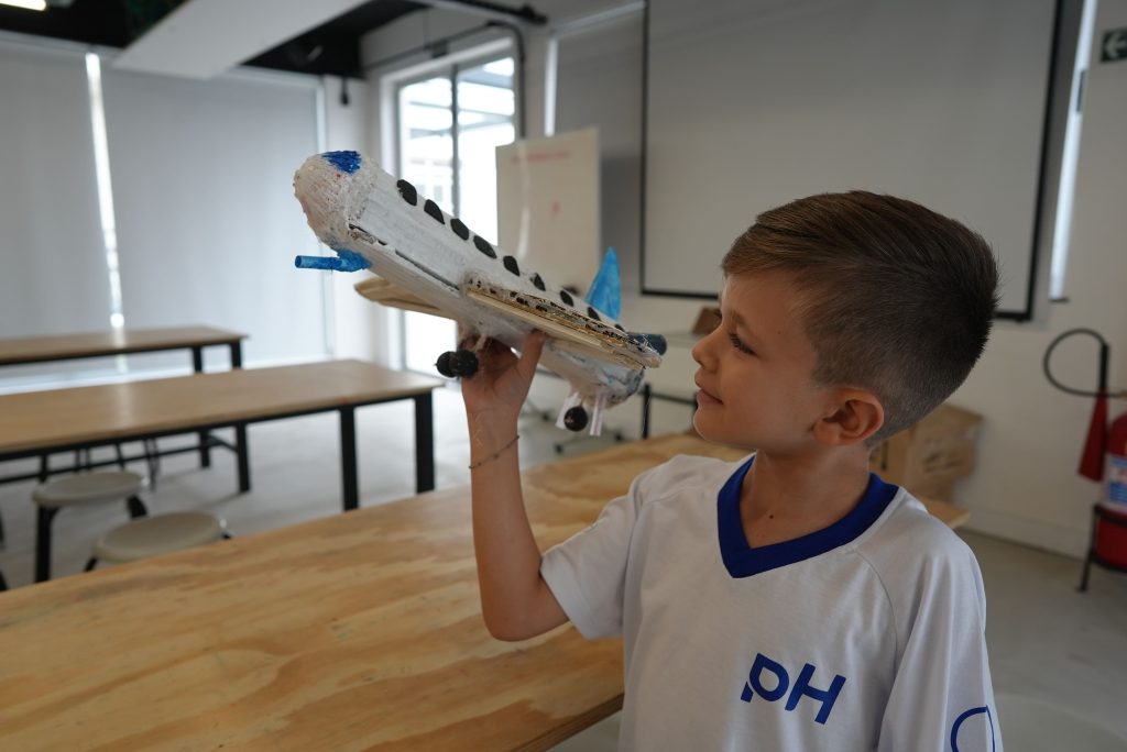aluno da escola de educação infantil ph seguranda um avião de brinquedo