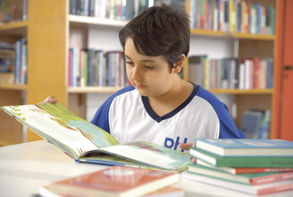 aluno lendo livro em um colégio bilíngue